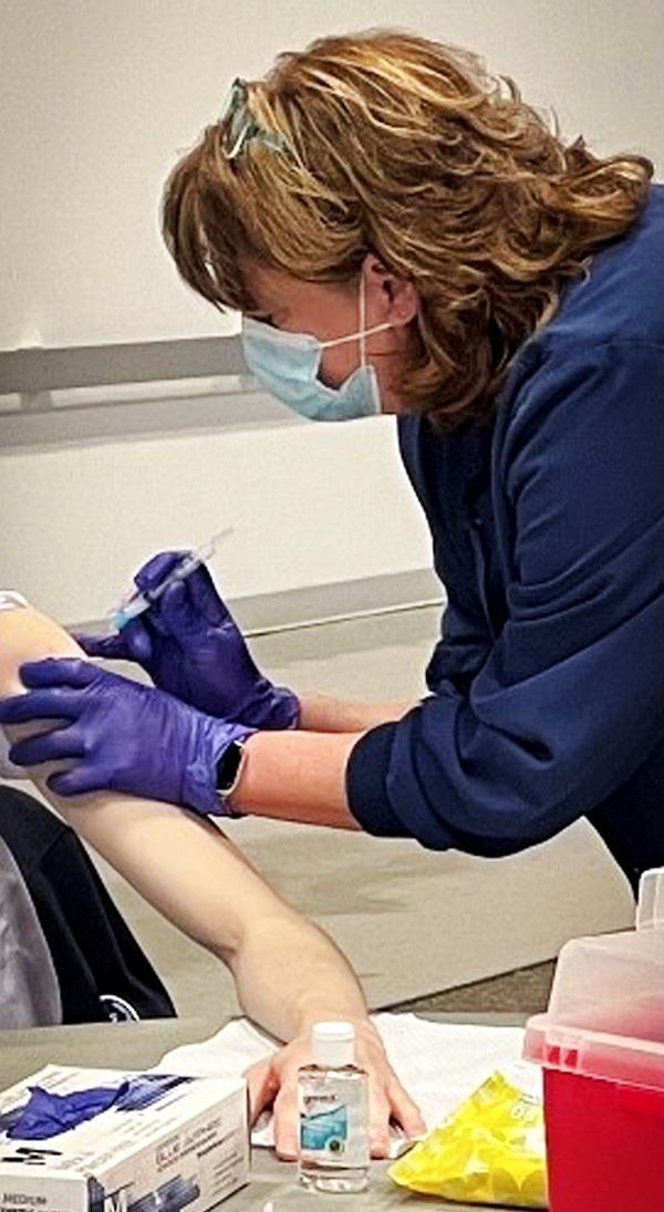 Dana Longmeyer, FNP, administers a COVID-19 vaccination at a clinic held at Lewis & Clark Community College on Jan. 26.