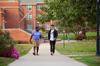 Two Male Students Walking On Campus