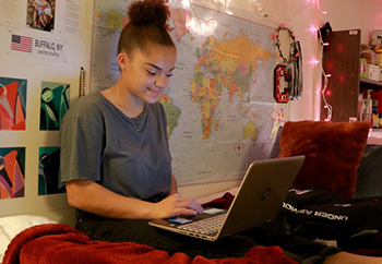 Female Student in Room on Laptop Computer