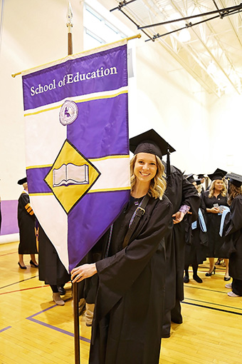 Student Holding School of Education Flag