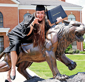 Graduate on Bearcat Statue