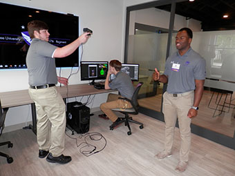 Kevin Magee scans a 3-D image of Jared Roulds-Griffin as Cole Nordmann watches it take shape on the monitor.