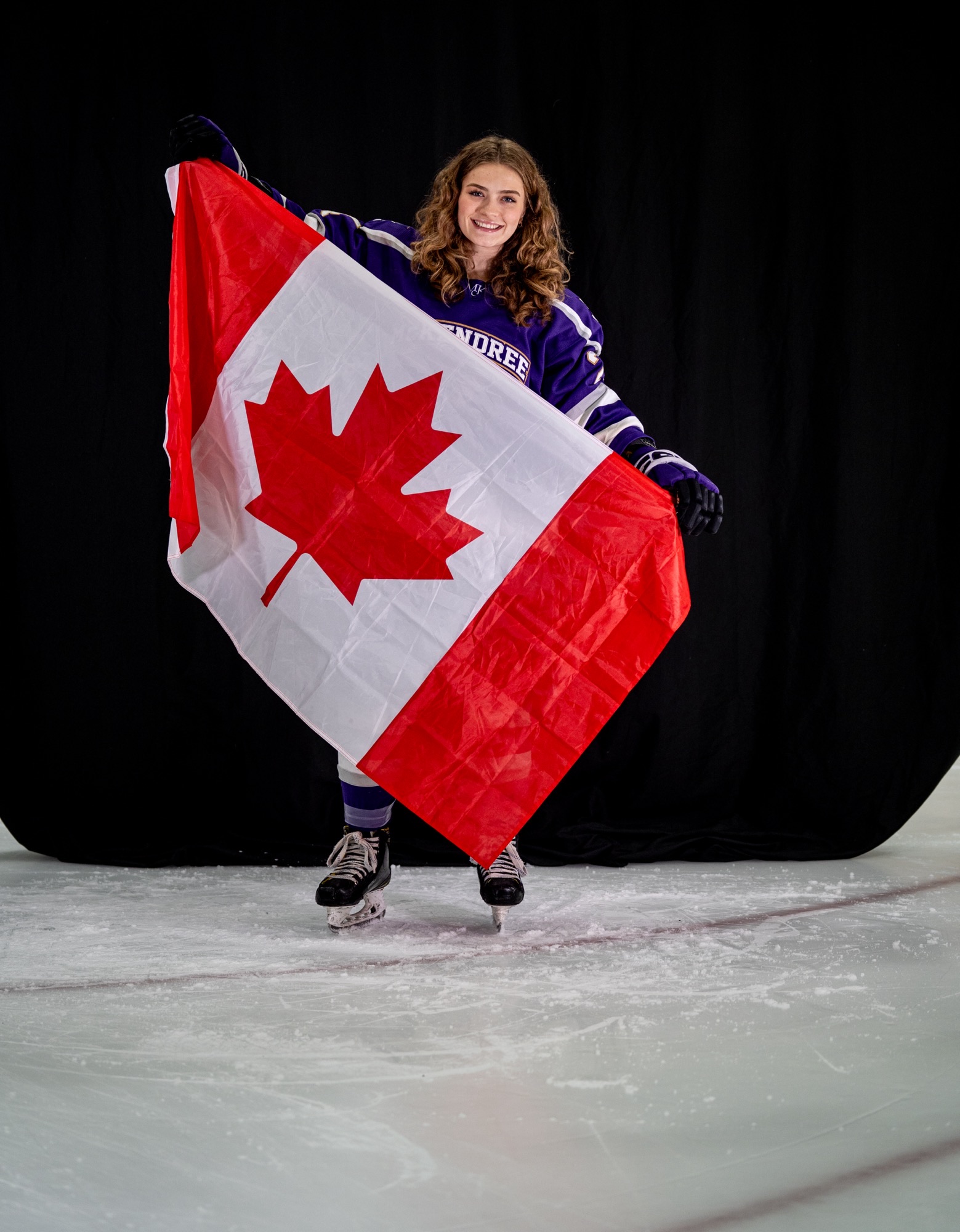 hockey player holding a Canadian flag