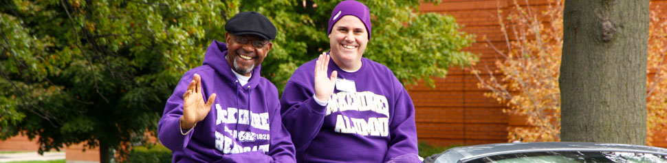 Two Male Alumni Waving Hands at Homecoming Parade